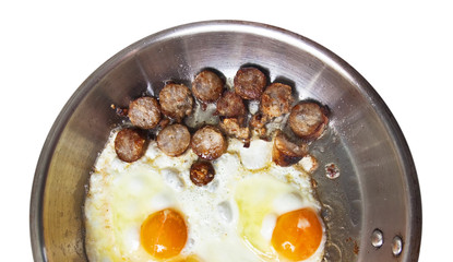 Frying pan with sausage slices and eggs