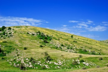 Fototapeta premium green hill under a cloudy sky