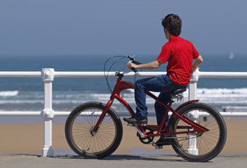 Joven en bicicleta frente al mar