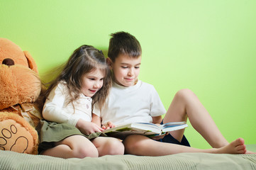Brother and sister reading a book