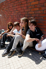 Naklejka premium Teenagers Sitting by a street