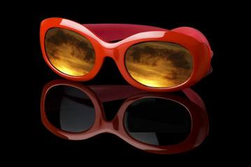 Futuristic sunglasses with sunset sky reflected over black