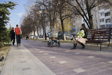 afternoon alley with two men running and woman with baby