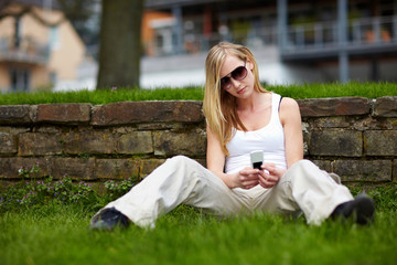 Frau mit Handy im Park © Robert Kneschke