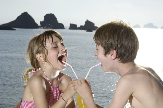 bambini ridono al mare con succo