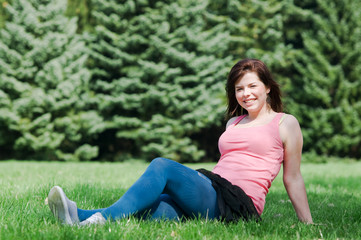 Fototapeta premium Young happy girl lying on grass