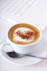 Cappuccino vor Laptop