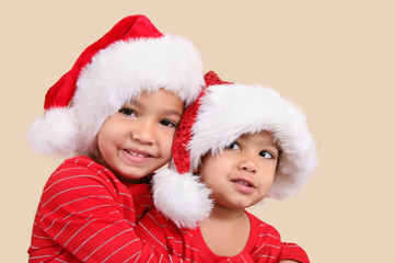 Two mixed race sisters in santa hats