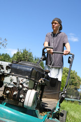 Fototapeta na wymiar Teenage boy mowing lawn