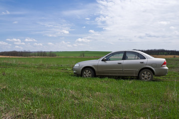 Obraz na płótnie Canvas Silver car on the green meadow
