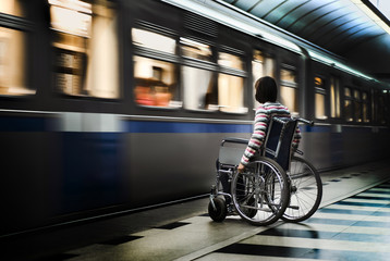 Woman in the wheelchair at the underground station