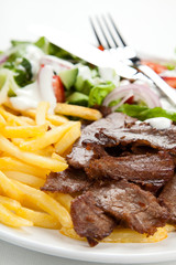 Grilled meat with fried potatoes and vegetables