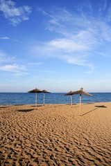 Blue beach in mediterranean sea with summer vacation umbrellas