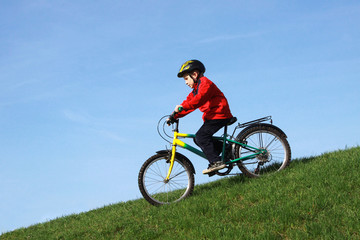Młody chłopiec zjeżdża na rowerze - obrazy, fototapety, plakaty