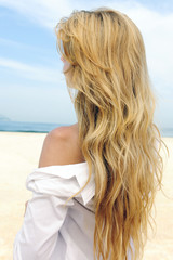 elegant woman with long blond hair at the beach
