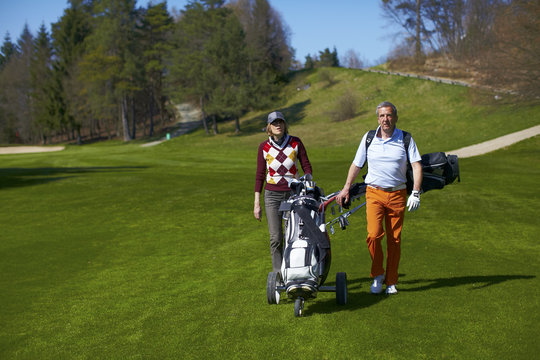 Man And Woman Walking On A Golf Course