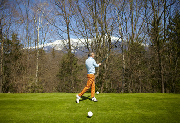 Obraz premium Man on a golf course after a swing with iron