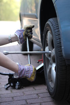 Eine Frau wechselt Reifen