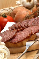 aufgeschnittene Salami auf einem Holzbrett