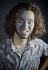 smiling young man in make-up, with long hair