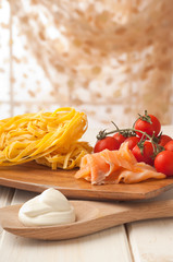cutting board with ingredients for salmon pasta