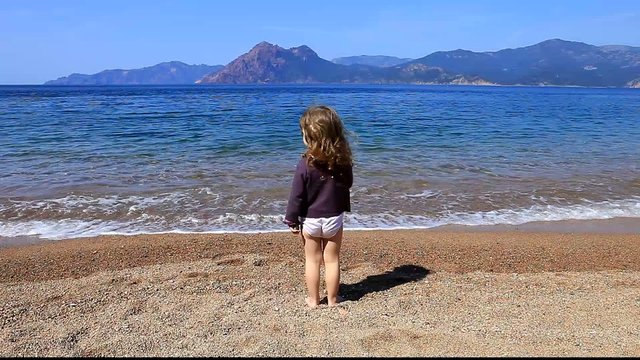 Enfant qui jete des pierres dans l'eau.