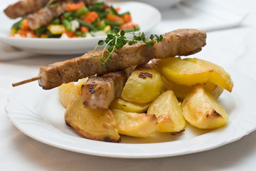 Schweinefleischspieße auf Ofenkartoffel