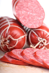 long loaf of smoked sausage lies on chopping board