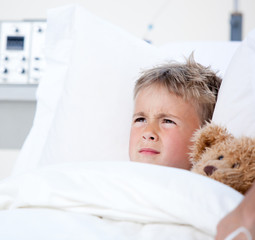 Sick little boy lying in a hospital bed