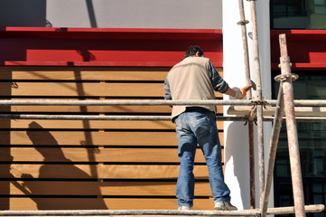 Naklejka na ściany i meble A construction worker on a high wall - CONSTRUCTION images