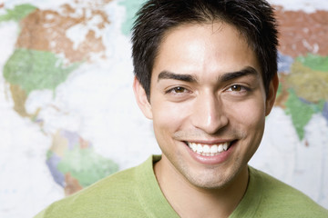 Portrait of Pacific Islander man in front of world map