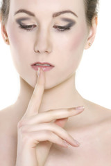 close up of beautiful woman with finger at her lips