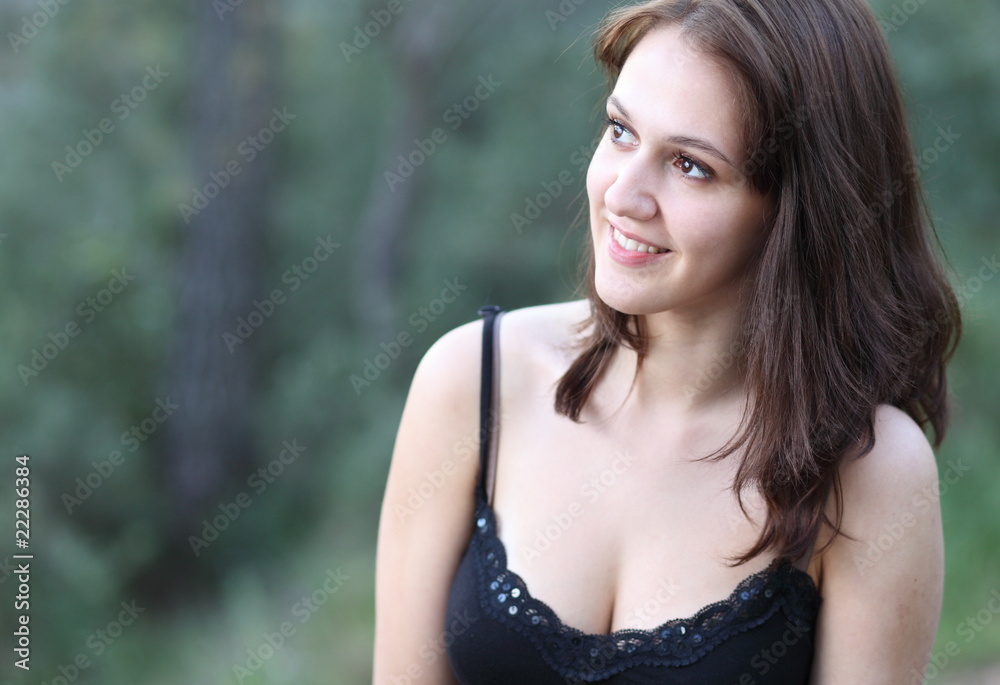 Wall mural Close-up portrait of a very pretty young brunette woman outdoo