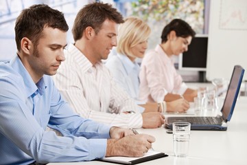 Businessman writing notes on meeting