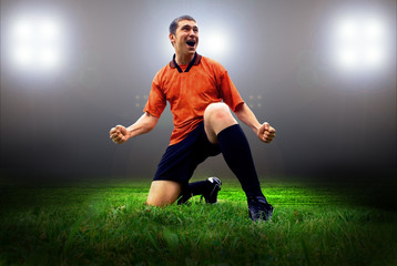 Fototapeta na wymiar Happiness football player after goal on the field of stadium wit