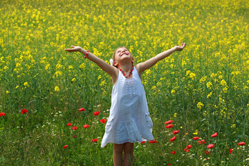 Pretty young girl surrounded by rapeseed flowers