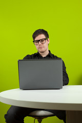 Young man sitting in the office and working on the laptop