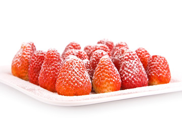 Erdbeeren mit Puderzucker auf Teller weiß isoliert