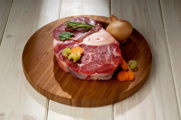 veal shank with ingredients ready to cook over cutting board