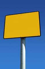 Blank yellow sign ready for text and blue sky.