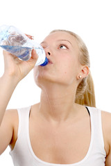 beautiful girl drinks mineral water from plastic bottle.