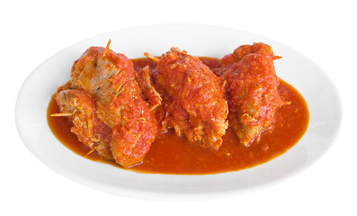 Meat roulade in tomato sauce on white dish.