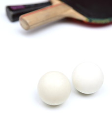 Two table tennis rackets and balls on white background.