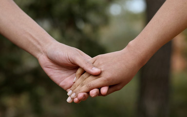 Lovers couple holding hands in a forest (summer/spring)