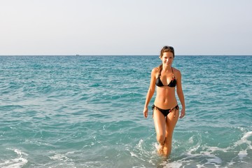 Obraz premium Beautiful young woman posing on the beach