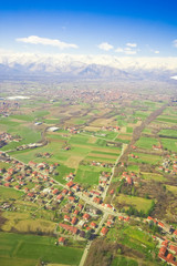 Fototapeta na wymiar Widok z lotu ptaka zielonego krajobrazu wiejskiego i domów z brązowymi dachami