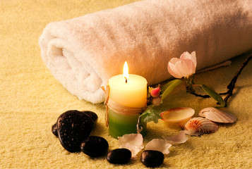 Towel, aromatic candles and other spa objects