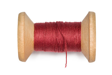 wooden coil with red threads isolated on white background