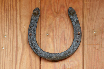 Old  lucky horseshoe on wooden new wall