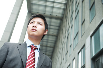 a yong Asiatic businessman  is standing outdoor